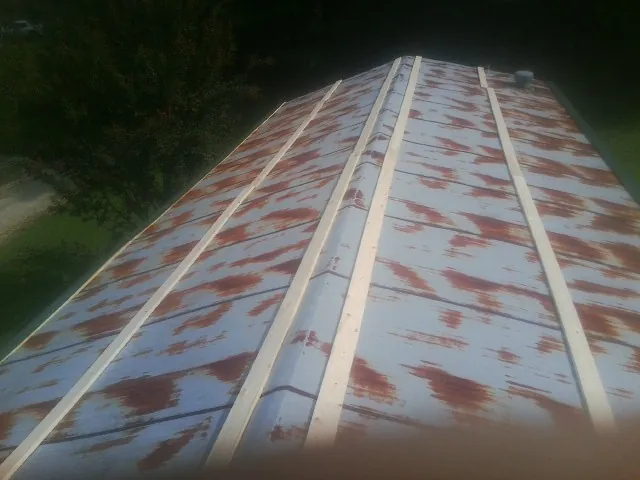 Rusted metal roof panels with new wood purlins before replacement — Storm Damage Roof Repair in Malin by Roofing Brothers