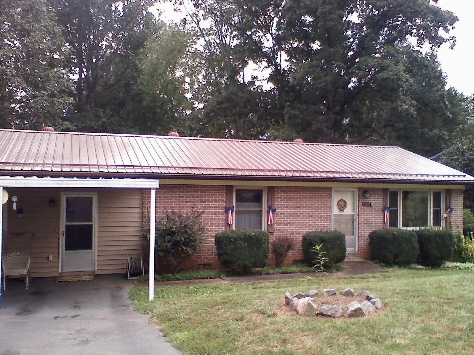 Bronze metal roof and carport on a brick ranch home — Roof Repair work by our crew in Malin
